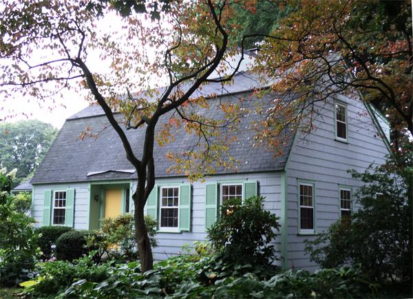 a front view of a house with yard and trees