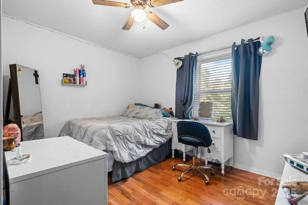 a bedroom with a bed and a chair with the potted plant