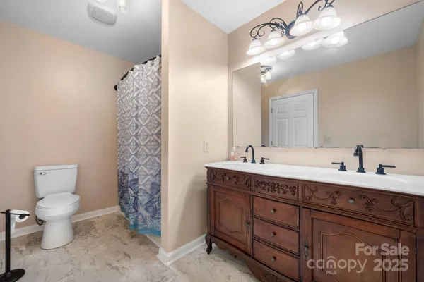 a bathroom with a double vanity sink mirror and toilet