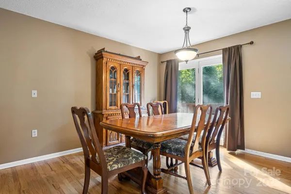 a dining room with furniture a chandelier and window