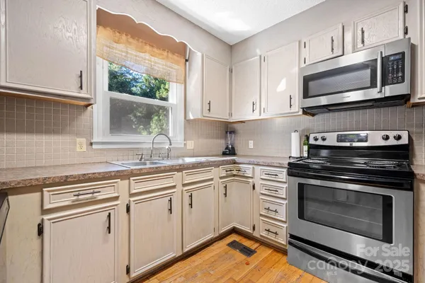 a kitchen with stainless steel appliances granite countertop a stove microwave and sink