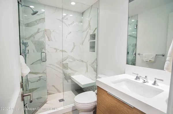 a bathroom with a sink toilet vanity and shower