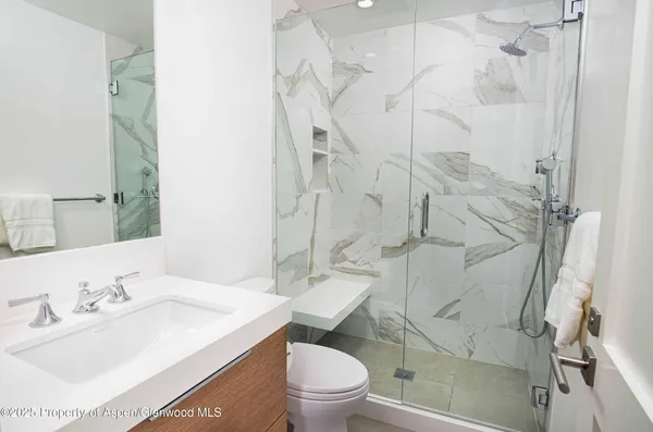 a bathroom with a sink toilet and shower