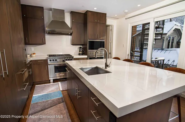 a kitchen with stainless steel appliances a sink a stove and a refrigerator
