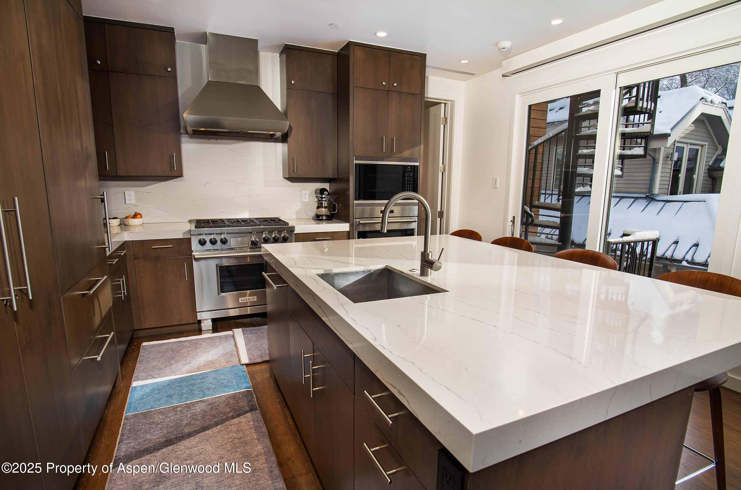 1018 East Hyman Avenue, Unit 1 Aspen, CO 81611 - Photo 4 of 28 a kitchen with stainless steel appliances a sink a stove and a refrigerator