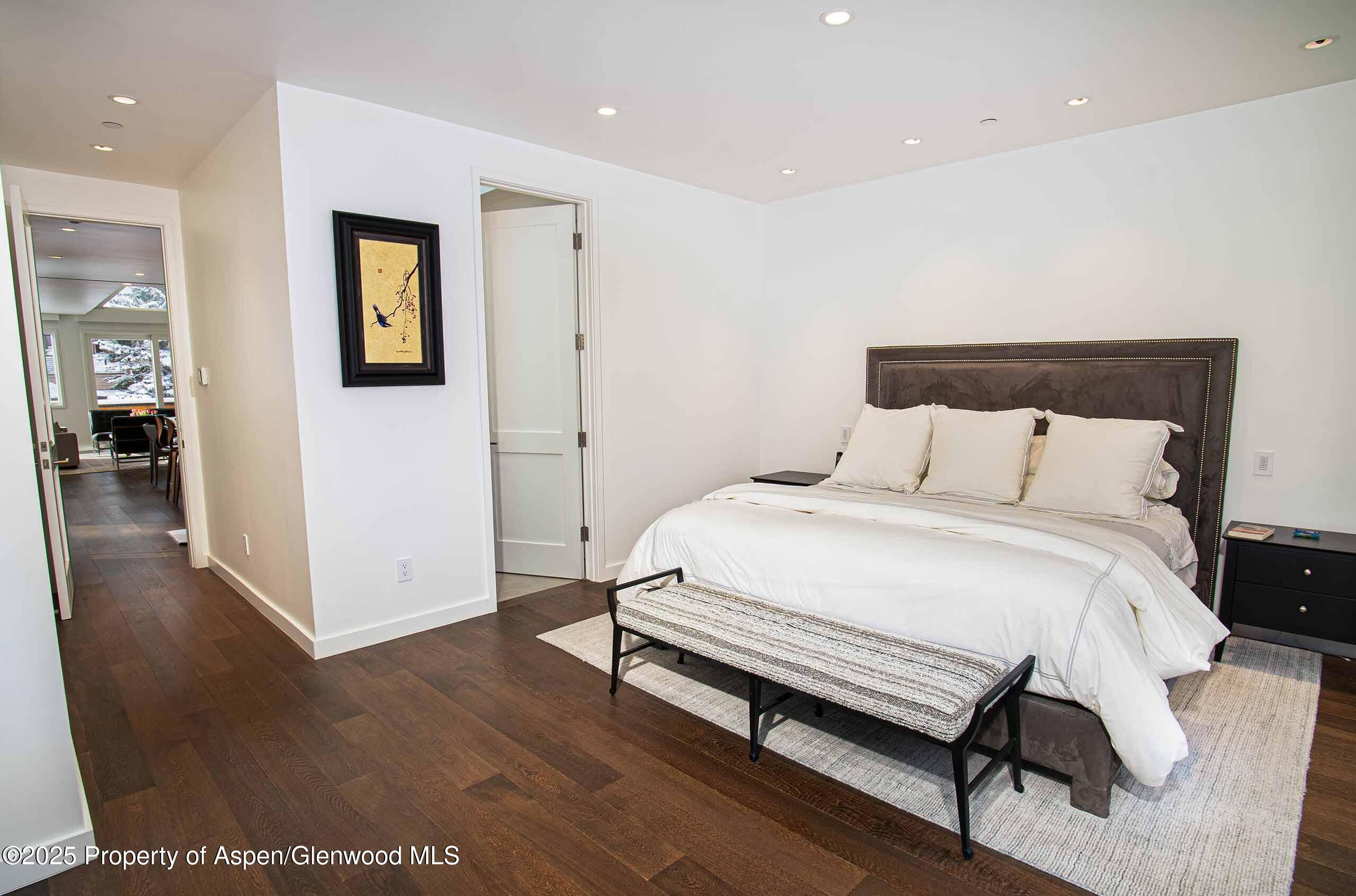 1018 East Hyman Avenue, Unit 1 Aspen, CO 81611 - Photo 7 of 28 a bedroom with a bed and wooden floor