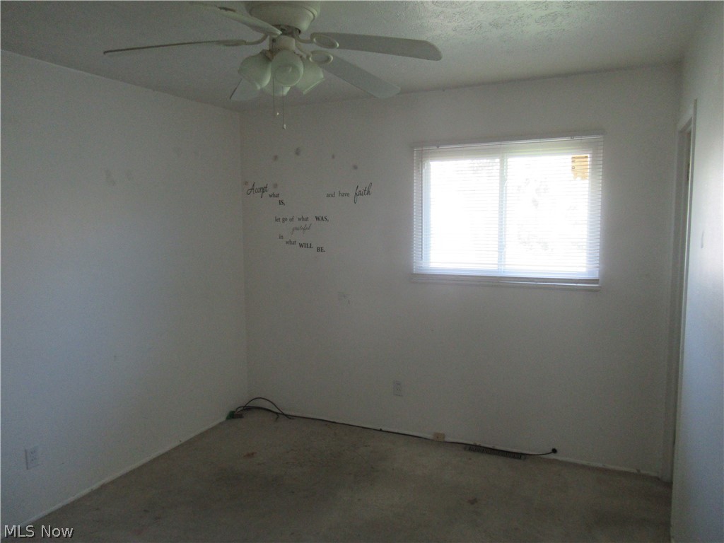 6033 Randy Road Bedford Heights, OH 44146 - Photo 14 of 19 Room featuring a window with horizontal blinds, a ceiling fan with light fixture, and textured walls