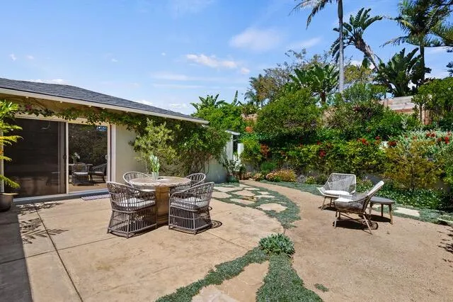 a view of a patio with table and chairs potted plants with wooden fence