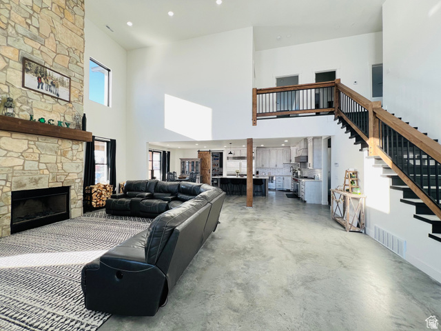100 Whit Lane Georgetown, ID 83239 - Photo 15 of 76 Living area featuring recessed lighting, concrete flooring, a high ceiling, and a fireplace