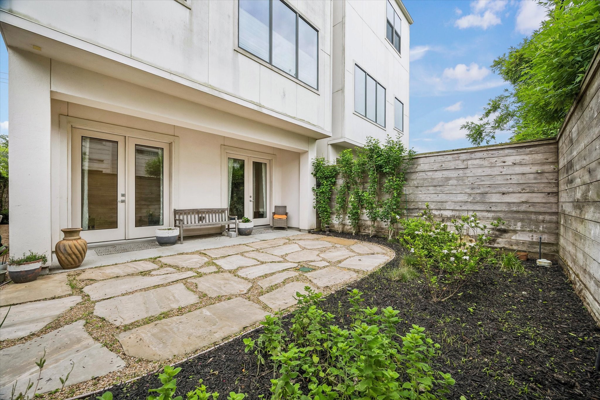 1526 Vermont Street Houston, TX 77006 - Photo 9 of 39 Private fenced yard with stone patio and landscaped borders, ideal for relaxing or outdoor entertaining.