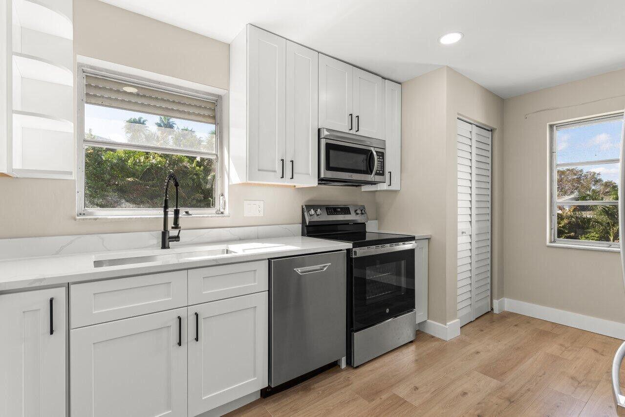 1 Harbourside Drive, Unit 1301 Delray Beach, FL 33483 - Photo 3 of 13 a kitchen with a sink stove and microwave