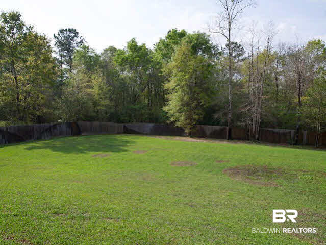 7814 Balin Drive Daphne, AL 36527 - Photo 24 of 26 Sprawling fenced yard with a natural backdrop,a pool and lounge area and a screened porch for great outdoor living or entertaining!