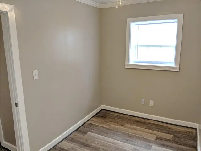 a view of a small space with wooden floor and a window