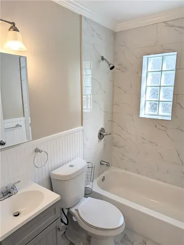 a bathroom with a bathtub toilet sink vanity and mirror