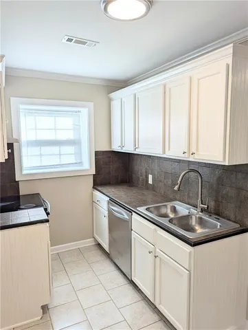 a kitchen with granite countertop a sink stove and cabinets