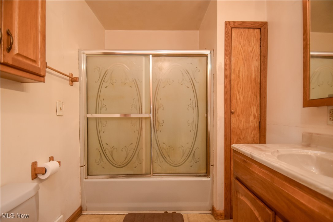 5382 West Webb Road Youngstown, OH 44515 - Photo 38 of 50 Full bathroom with tile patterned floors, toilet, vanity, and enclosed tub / shower combo