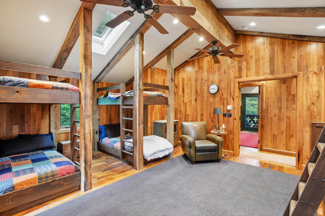 10205 East Moose Loop Road Salt Lake City, UT 84121 - Photo 24 of 50 Vaulted ceiling room featuring extensive wood-paneled walls, exposed wood beams, and wood-finish flooring