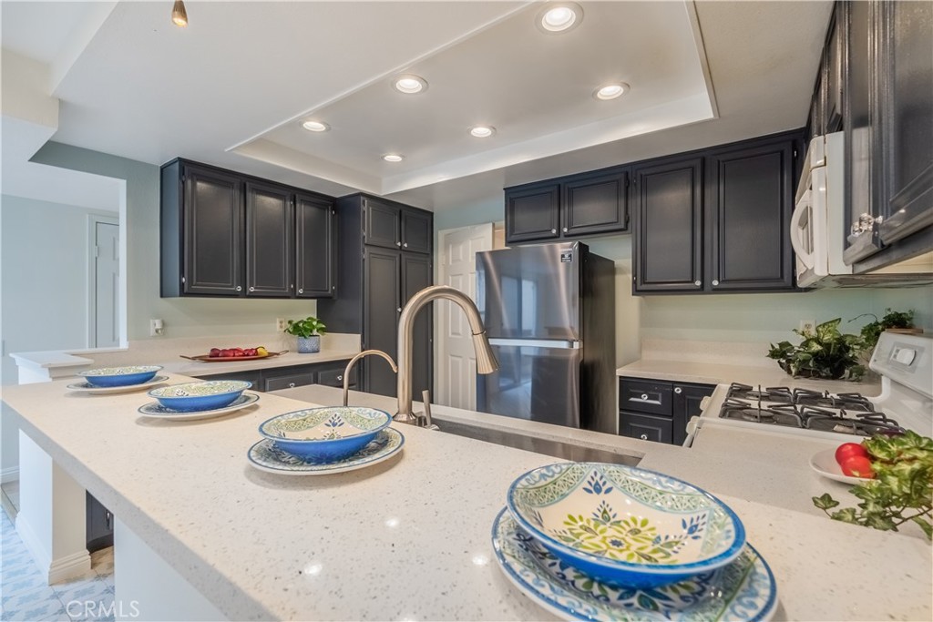 19 Dartmouth Irvine, CA 92612 - Photo 11 of 44 a kitchen with refrigerator and chairs