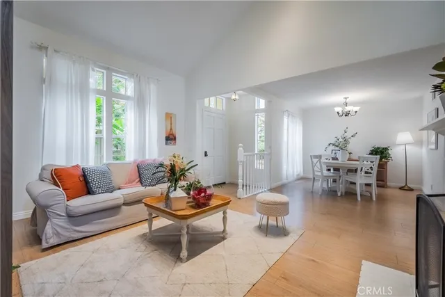 a dining room with furniture a chandelier and wooden floor