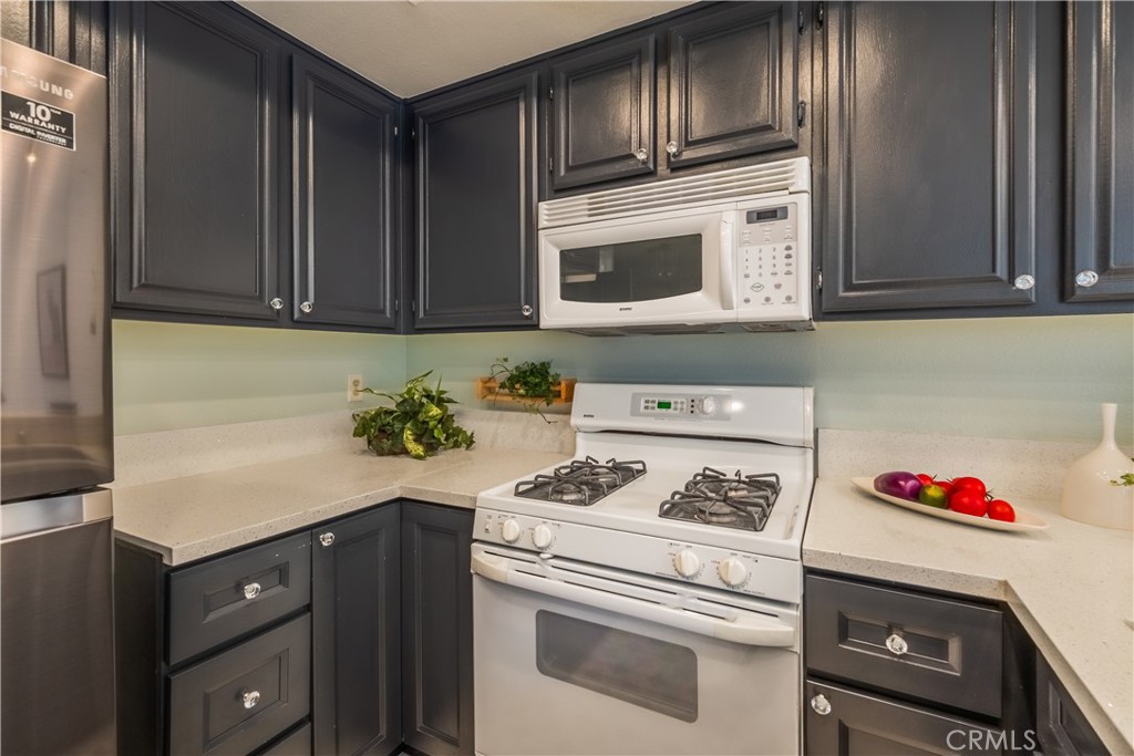 19 Dartmouth Irvine, CA 92612 - Photo 8 of 44 a kitchen with granite countertop cabinets stove top oven and microwave