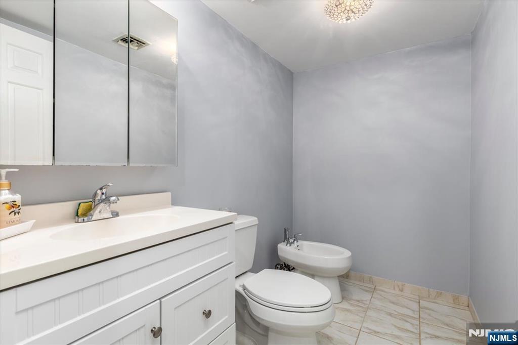 2 Crystal Lane, Unit 294 Paterson, NJ 07501 - Photo 20 of 30 a bathroom with a toilet sink vanity and mirror