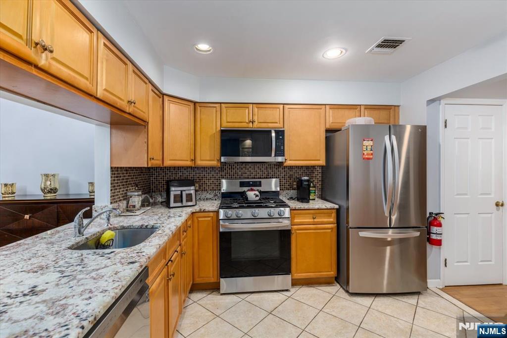 2 Crystal Lane, Unit 294 Paterson, NJ 07501 - Photo 2 of 30 a kitchen with a refrigerator a stove and a sink