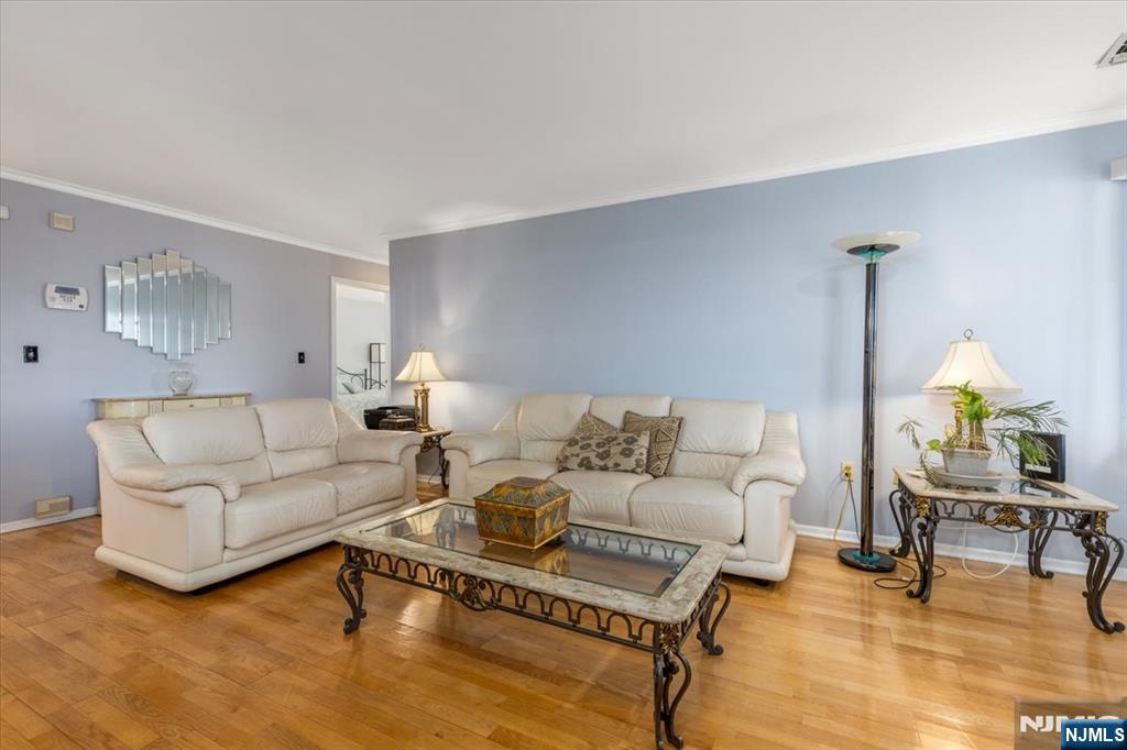 2 Crystal Lane, Unit 294 Paterson, NJ 07501 - Photo 5 of 30 a living room with furniture a lamp and a dining table with wooden floor