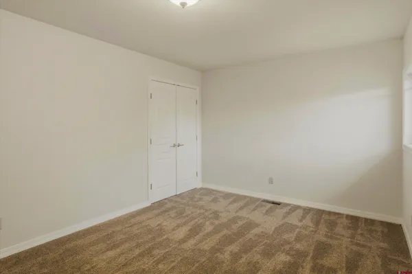 a view of an empty room with a kitchen