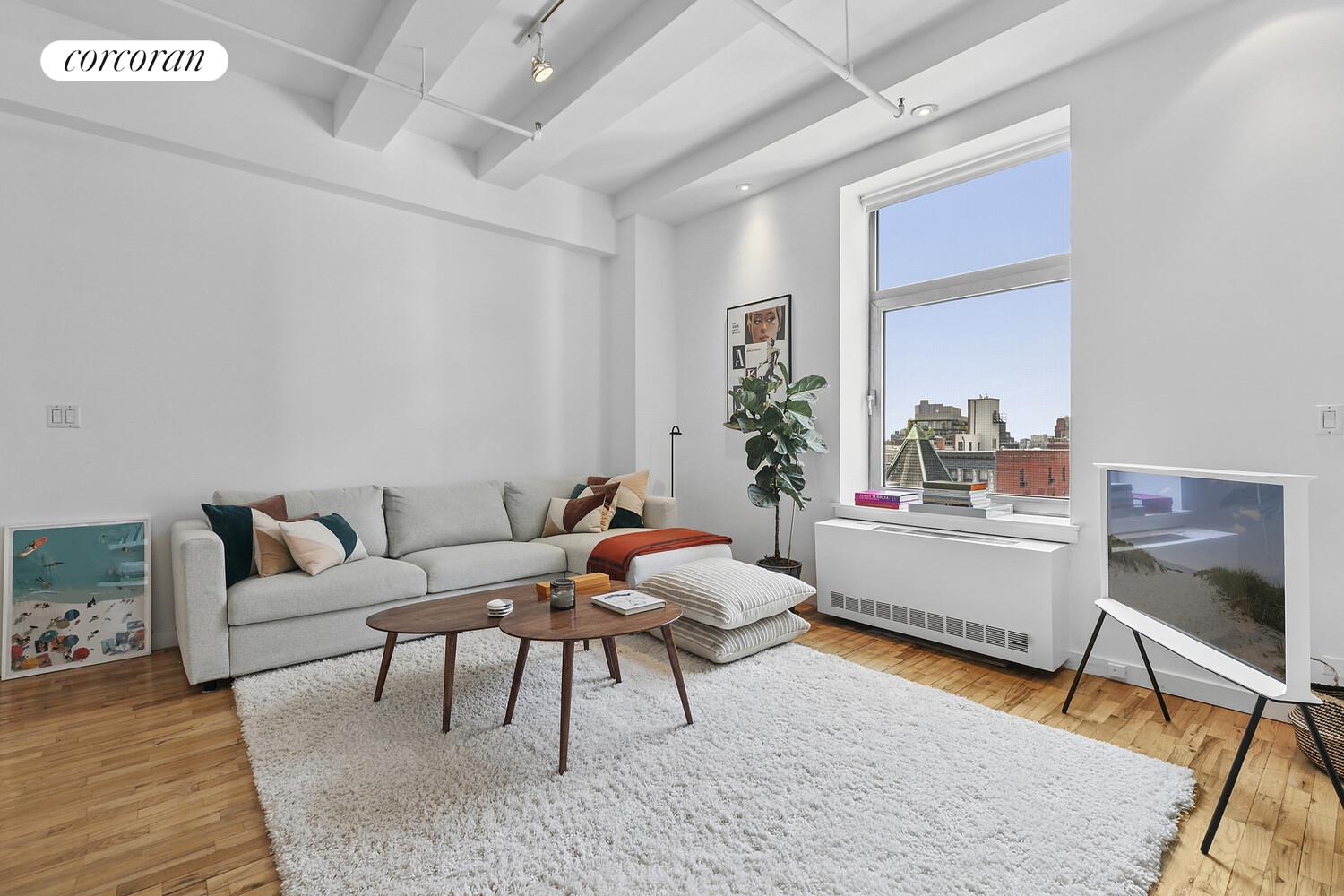 14 East 4th Street, Unit 827 Manhattan, NY 10012 - Photo 3 of 10 a living room with furniture and a wooden floor