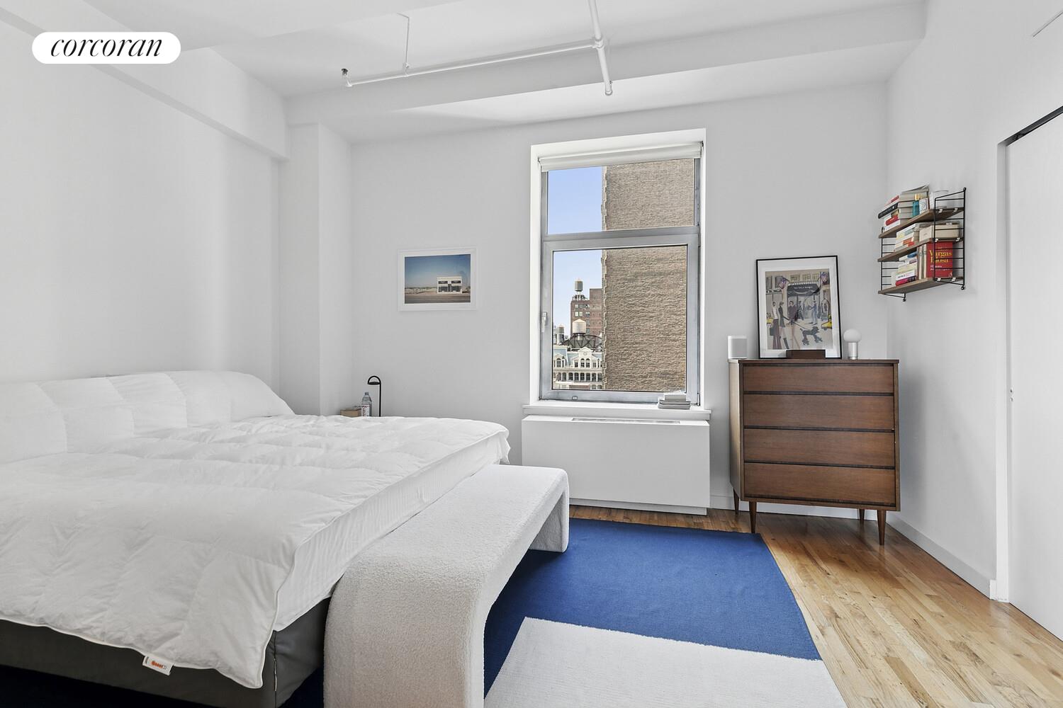 14 East 4th Street, Unit 827 Manhattan, NY 10012 - Photo 5 of 10 a bedroom with a bed and wooden floor
