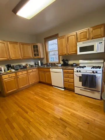 a large kitchen with stainless steel appliances granite countertop a stove a sink and a microwave