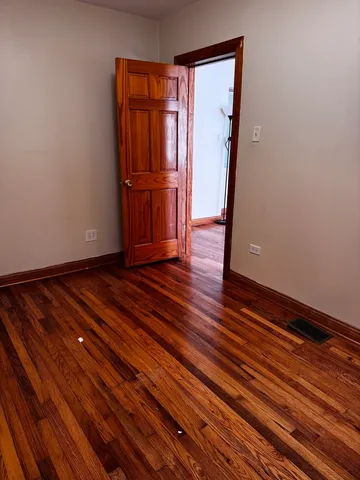 a view of empty room with wooden floor and cabinet