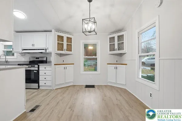 a kitchen with cabinets wooden floor and a window