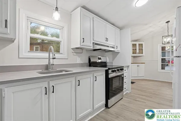 a kitchen with granite countertop white cabinets and stainless steel appliances