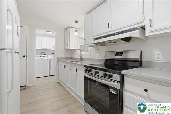 a kitchen with stainless steel appliances white cabinets and a stove