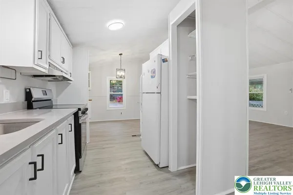a kitchen with cabinets and a refrigerator