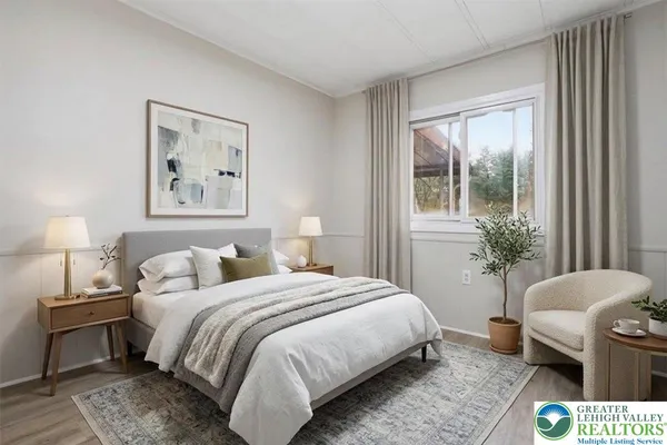 a bedroom with a bed a couch and potted plant with a large window