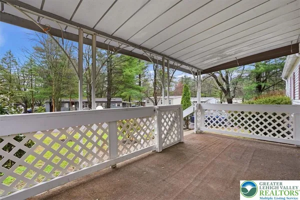 a view of a roof deck with wooden fence and trees
