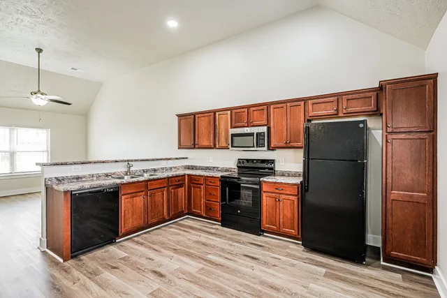 a kitchen with stainless steel appliances granite countertop a refrigerator stove and sink