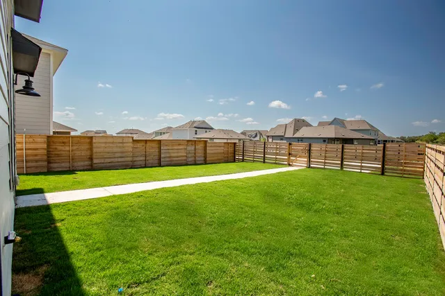 a view of a backyard with a garden and entertaining space