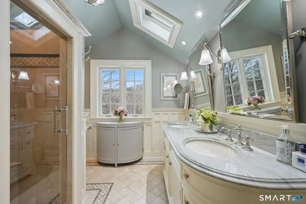 a bathroom with a granite countertop sink a mirror and a shower
