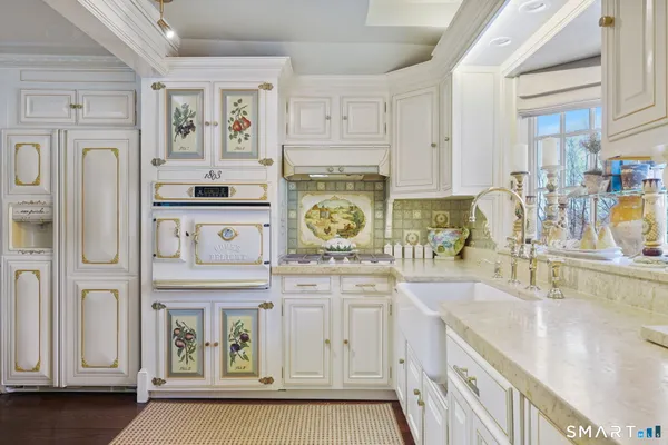 a kitchen with stainless steel appliances granite countertop a sink a stove and cabinets
