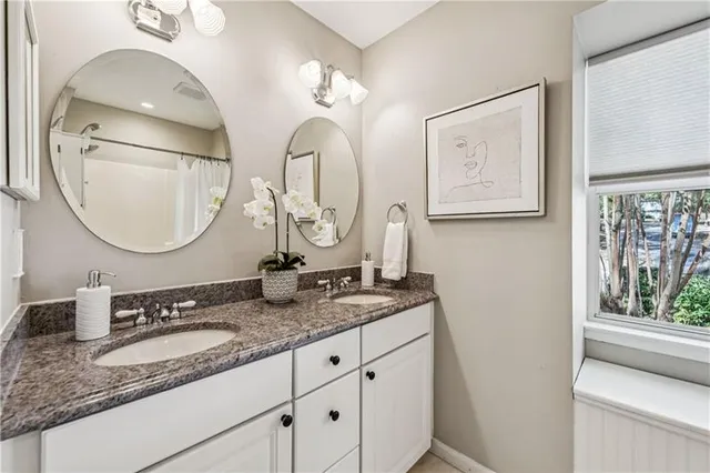 a bathroom with a granite countertop double vanity sinks and a mirror