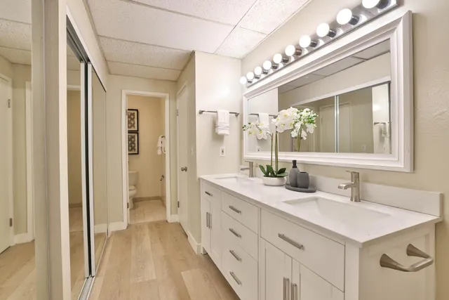a spacious bathroom with a double vanity sink a mirror and a shower