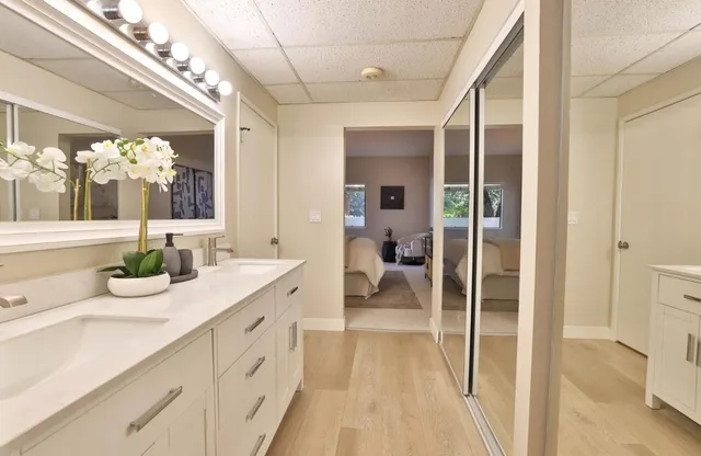 a spacious bathroom with a double vanity sink a mirror and a shower