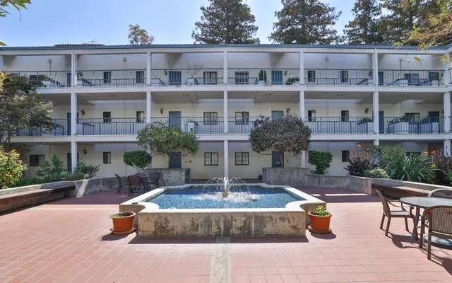 a view of a building with garden and sitting area
