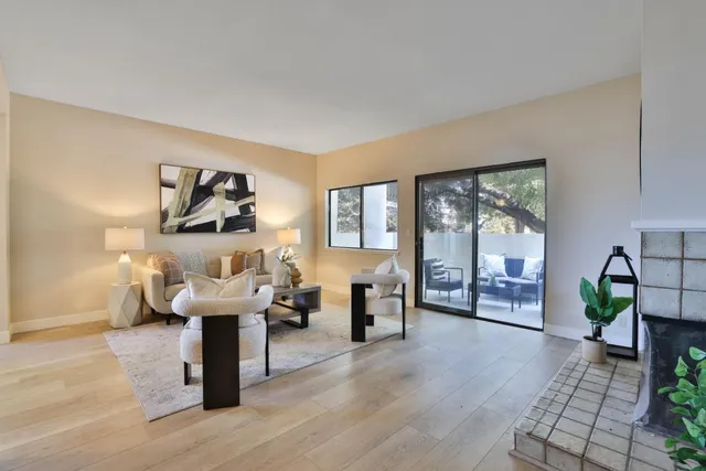 a living room with furniture a wooden floor and next to a window