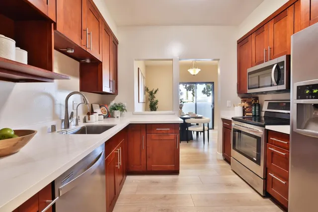 a kitchen with stainless steel appliances granite countertop sink stove top oven and cabinets