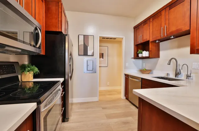 a kitchen with stainless steel appliances granite countertop a sink stove and refrigerator