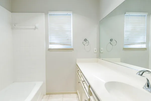 a bathroom with a tub sink and a window